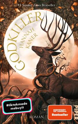 Godkiller Das Buchcover zeigt einen majestätischen Hirsch vor einem großen, leuchtenden Vollmond. Die Farbpalette umfasst warme Brauntöne und sanfte, goldene Akzente. Der Titel „GODKILLER“ prangt in großen, auffälligen Buchstaben oberhalb des Hirsches, während der Autorennamen „Hannah Kaner“ in schlichterer Schrift darunter steht. Aus dem Hintergrund schlängeln sich dunkle Äste, die eine mystische Atmosphäre erzeugen. In der unteren Ecke sind zwei farbige Sticker mit den Aufschriften „#tiktokmade“ und „SPIEGEL Bestseller“ platziert.