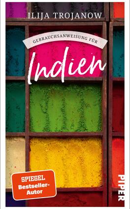 Gebrauchsanweisung für Indien Das Buchcover zeigt eine Holzwand mit mehreren Fächern, die bunt gefüllte Pulvertöpfe enthalten. Die Farben der Töpfe variieren zwischen kräftigen Grün-, Blau-, Gelb- und Rottönen und strahlen Lebendigkeit aus. Darüber steht der Titel „Gebrauchsanweisung für Indien“ in schwungvoller, weißer Schrift. Der Autorenname „Ilija Trojanow“ ist in einer schlichten Schrift oberhalb des Titels platziert. Ein rotes Banner am unteren Bildrand hebt den Hinweis „SPIEGEL Bestseller-Autor“ hervor.