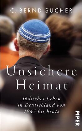 Unsichere Heimat Das Buchcover zeigt eine Nahaufnahme des Hinterkopfes eines Mannes mit einer blauen Kippa. Im Hintergrund sind unscharfe, dunkle Silhouetten von Menschen zu sehen, die eine nachdenkliche Atmosphäre vermitteln. Der Titel „Unsichere Heimat“ hebt sich in eleganter Schrift in Weiß ab und steht prominent im Mittelpunkt. Darunter befindet sich der Untertitel „Jüdisches Leben in Deutschland von 1945 bis heute“ in kleinerer, weißer Schrift. Die Farbgestaltung ist warm und einladend.