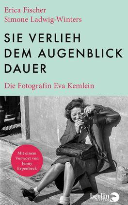 Sie verlieh dem Augenblick Dauer Das Buchcover zeigt im oberen Drittel ein mintgrünes Feld mit dem großen, schwarzen, serifenlosen Titel in Versalien „SIE VERLIEH DEM AUGENBLICK DAUER“; links oben stehen in roter Serifenschrift die Autorennamen Erica Fischer und Simone Ladwig-Winters, darunter in kleiner roter Serifenschrift der Untertitel Die Fotografin Eva Kemlein. Die untere Hälfte zeigt ein schwarzweißes Foto einer lächelnden Frau, die mit einer Kamera auf dem Gehsteig sitzt; Atmosphäre: nostalgisch, dokumentarisch.