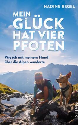 Mein Glück hat vier Pfoten Das Buchcover zeigt eine wandernde Frau mit ihrem Hund an einem klaren Gebirgsbach. Die Atmosphäre ist lebhaft und naturverbunden, geprägt von strahlendem Himmel und majestätischen Bergen im Hintergrund. Die Farben sind frisch, mit einem dominierenden Blau und Erdtönen. Der Titel „Mein Glück hat vier Pfoten“ steht in großen, weißen, leicht verschnörkelten Buchstaben oben, während der Untertitel „Wie ich mit meinem Hund über die Alpen wanderte“ in einer schlichteren Schrift darunter zu finden ist. Nadine Regel ist als Autorin genannt.