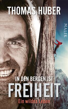 In den Bergen ist Freiheit Das Buchcover zeigt das Portrait eines lächelnden Mannes mit langen Haaren, vor einer beeindruckenden Felswand. Auf der rechten Seite ist ein Kletterer in roten Kleidungsstücken zu sehen, der an der Felswand emporsteigt. Der Hintergrund ist in einem hellen Blau gehalten, das die Weite des Himmels vermittelt. Der Titel „IN DEN BERGEN IST FREIHEIT“ ist in großen, grauen Buchstaben hervorgehoben, während der Untertitel „Ein wildes Leben“ in einer kleineren Schrift darunter steht. Der Autorenname „THOMAS HUBER“ befindet sich ganz oben auf dem Cover.