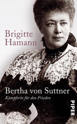 Bertha von Suttner Das Buchcover zeigt ein portraitiertes Foto von Bertha von Suttner in historischer Tracht. Ihre ernste Miene und der direkte Blick verleihen der Komposition eine eindringliche Atmosphäre. Der Hintergrund ist in Schwarz-Weiß gehalten, während die Schriftzüge „Brigitte Hamann“ und „Bertha von Suttner - Kämpferin für den Frieden“ in einem sanften Braunton erscheinen. Die Typografie ist klar und modern, die Titelinformationen sind gut lesbar und heben sich von der Bildfläche ab.