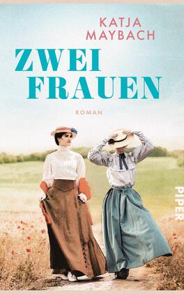 Zwei Frauen Das Buchcover zeigt zwei Frauen in historischer Kleidung, die nebeneinander auf einem blühenden Feld stehen. Die linke Frau trägt ein schlichtes, helles Oberteil und einen langen, roten Rock, während die rechte Frau in einem blauen Outfit und einem weitreichenden Hut zu sehen ist. Der Titel „Zwei Frauen“ steht in großen, türkisfarbenen Buchstaben mittig auf dem Cover, während darunter das Wort „Roman“ in kleinerer Schrift positioniert ist. Der Name der Autorin, Katja Maybach, ist oben in einer eleganten Schriftart platziert.
