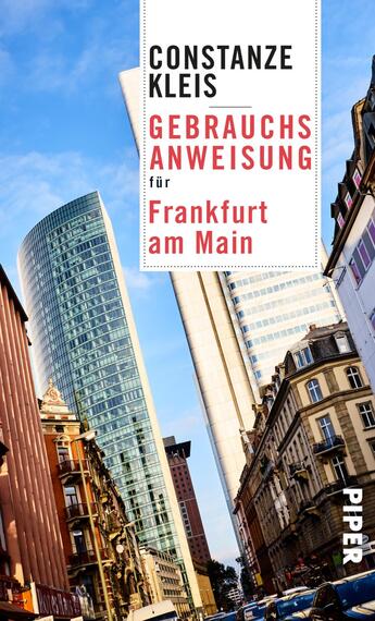 Das Buchcover zeigt eine moderne Frankfurter Stadtszene mit hoch aufragenden Glas- und Betonstrukturen, die in den Himmel ragen. Die linke Seite wird von historischen Gebäuden mit klassischen architektonischen Details geprägt, während die rechte Seite von einem futuristischen Wolkenkratzer dominiert wird. Der Titel „Gebrauchsanweisung für Frankfurt am Main“ ist in prägnanten roten Buchstaben auf hellem Hintergrund platziert, während der Name der Autorin „Constanze Kleis“ in einer eleganten schwarzen Schrift darüber steht. Die Farbpalette umfasst Kräftiges Blau, Weiß, Schwarz und Rot, die eine dynamische und einladende Atmosphäre schaffen.