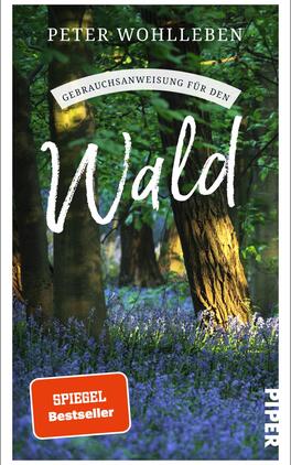 Gebrauchsanweisung für den Wald Das Buchcover zeigt einen lichtdurchfluteten Wald mit üppigem Grün und blühenden, violetten Pflanzen im Vordergrund. Der Titel „Wald“ ist in großer, geschwungener Schrift in Weiß gehalten, darüber steht der Untertitel „Gebrauchsanweisung für den“ in schlichter, kleinerer Schrift. Der Name des Autors, Peter Wohlleben, ist oben auf dem Cover abgedruckt. In der unteren linken Ecke befindet sich ein rotes Feld mit der Aufschrift „SPIEGEL Bestseller“. Das Cover vermittelt eine ruhige und einladende Atmosphäre, die die Schönheit der Natur hervorhebt.