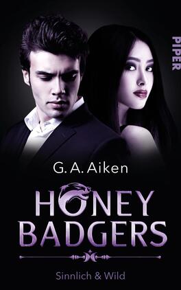 Honey Badgers Das Buchcover zeigt einen dramatischen Kontrast zwischen einem männlichen und einem weiblichen Protagonisten. Der Mann trägt ein dunkles Hemd und hat einen nachdenklichen Gesichtsausdruck, während die Frau mit langem, schwarzem Haar und einem verführerischen Blick in die Kamera schaut. Die Hintergrundfarbe ist ein tiefes Schwarz, das die Figuren hervorhebt. Der Titel „HONEY BADGERS“ in geschwungener, lila Schrift steht zentral, während der Autorennamen „G. A. Aiken“ darüber platziert ist. Unten steht der Untertitel „Sinnlich & Wild“ in einer eleganten Schrift.