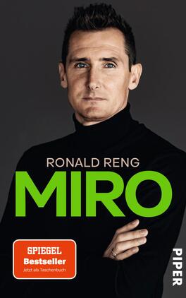 Miro Das Buchcover zeigt eine Porträtaufnahme eines Mannes mit kurzem, dunklem Haar und einem entschlossenen Blick. Er trägt einen schwarzen Rollkragenpullover, der einen eleganten Kontrast zu dem neutralen Hintergrund bildet. Der Titel „MIRO“ ist in großen, kräftigen grünen Buchstaben prominently platziert. Darunter steht der Autor „RONALD RENG“ in kleinerer, weißer Schrift. Ein rotes Label weist auf den Status als „SPIEGEL Bestseller“ hin, mit dem Zusatz „Jetzt als Taschenbuch“ darunter, während das Verlagslogo am rechten Coverrand zu sehen ist.