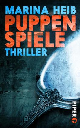Puppenspiele Das Buchcover zeigt einen düsteren, blauen Hintergrund, der die Atmosphäre eines Thrillers vermittelt. Im Vordergrund ist ein verziertes Silberbesteck abgebildet, das einen antiken Spiegel hält. Der Titel „Puppenspiele“ von Marina Heib ist in auffälligen, orangefarbenen Buchstaben geschrieben, während darunter das Wort „Thriller“ in kleinerer, weißer Schrift erscheint. Die Farbkontraste schaffen einen spannungsgeladenen Eindruck.
