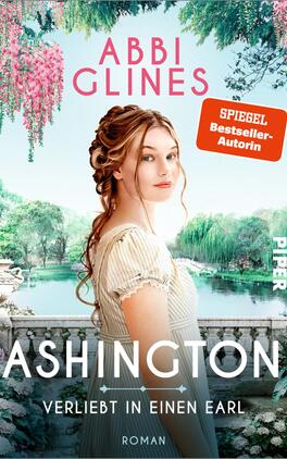Ashington – Verliebt in einen Earl Das Buchcover zeigt eine junge Frau mit langen, gewellten Haaren, die in einem romantischen Garten steht. Sie trägt ein helles, schlichtes Kleid und blickt direkt in die Kamera. Im Hintergrund sind üppige Pflanzen und blühende Bäume zu sehen, die eine idyllische Atmosphäre schaffen. Der Titel „ASHINGTON – Verliebt in einen Earl“ erscheint in großen, weißen Buchstaben am unteren Rand. Oben steht „ABBI GLINES“ in rosa und der Hinweis „SPIEGEL Bestseller-Autorin“ in einer orangefarbenen Box.