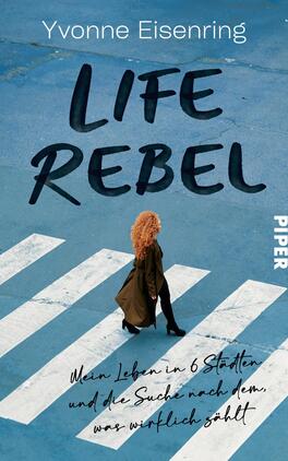 Life Rebel Das Buchcover zeigt eine Person mit lockigem, orangem Haar, die auf einem stilisierten Zebrastreifen geht. Der Hintergrund ist in einem hellen Blau gehalten, was eine frische Atmosphäre vermittelt. Der Titel „LIFE REBEL“ ist in großen, schwarzen Buchstaben zentral platziert. Darunter steht der Untertitel „Mein Leben in 6 Städten und die Suche nach dem, was wirklich zählt“ in einer handschriftlichen Schriftart. Das Verlagssymbol „PIPER“ ist in der rechten unteren Ecke in Weiß abgedruckt.