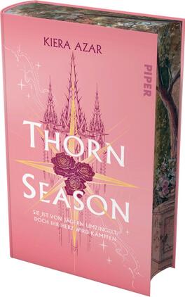 Thorn Season Das Buchcover zeigt einen sanften rosafarbenen Hintergrund. Zentral platziert ist der Titel „THORN SEASON“ in großen, weißen Buchstaben, umgeben von zarten, stilisierten Rosen in tiefem Rot. Über dem Titel erstrecken sich strahlende goldene Linien und Symbole, die Spannung und Magie vermitteln. Am oberen Rand befindet sich der Name der Autorin, Kiera Azar, in eleganter Schrift. Unter dem Titel steht der Satz „Sie ist von Jägern umzingelt, doch ihr Herz wird kämpfen“ in klarer, schmaler Schrift.