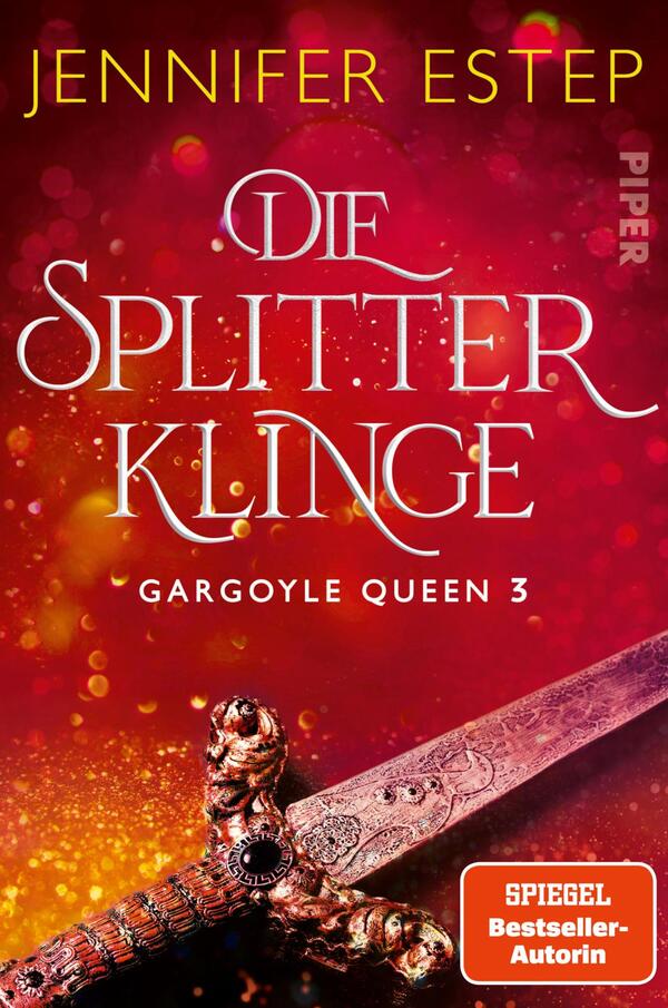 Das Buchcover zeigt einen rot-goldenen Hintergrund mit funkelnden Lichteffekten, die eine mysteriöse Atmosphäre erzeugen. Im Vordergrund ist eine prächtig verzierte Klinge zu sehen, deren Griff mit detailreichen Ornamenten versehen ist. Der Titel „Die Splitterklinge“ ist in eleganter, geschwungener Schrift in Weiß gehalten, während der Zusatz „Gargoyle Queen 3“ in kleinerer Schrift darunter steht. Oben links steht der Name der Autorin, Jennifer Estep, ebenfalls in goldener Schrift.