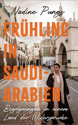 Frühling in Saudi-Arabien Das Buchcover zeigt eine Frau, die durch eine historische Gasse in Saudi-Arabien geht. Sie trägt ein beiges, langes Kleid und einen Schal. Im Hintergrund sind traditionelle Gebäude und eine helle Himmel zu sehen. Die Titelzeile „FRÜHLING IN SAUDI-ARABIEN“ ist in großen, orangefarbenen Buchstaben platziert, während der Untertitel „Begegnungen in einem Land der Widersprüche“ in kleineren, schwarzen Buchstaben darunter steht. Der Name der Autorin, Nadine Pungs, befindet sich oben in verschnörkelter Schrift. Die Farbgestaltung vermittelt eine warme, einladende Atmosphäre.