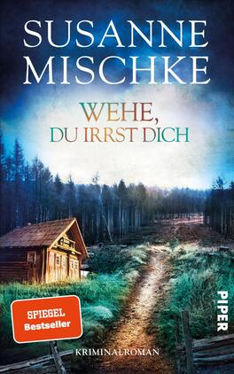 Wehe, du irrst dich Das Buchcover zeigt eine mysteriöse Waldlandschaft mit einem schmalen, unebenen Weg, der in die Ferne führt. Auf der linken Seite steht eine rustikale Holzschutzhütte. Der Hintergrund ist in dunklen Blau- und Grautönen gehalten, während der Titel „WEHE, DU IRRST DICH“ in aquamarinen Buchstaben leuchtet. Der Name der Autorin, „SUSANNE MISCHKE“, ist prominent oben in weißer Schrift platziert. Ein rotes Label mit dem Text „SPIEGEL Bestseller“ hebt sich deutlich vom Hintergrund ab.