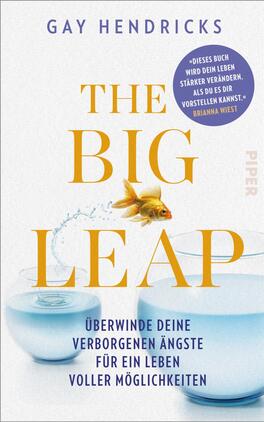 The Big Leap Das Buchcover zeigt einen hellen, minimalistischen Hintergrund. In der Mitte befindet sich der Titel „THE BIG LEAP“ in großen, gelben Buchstaben. Darunter steht der Untertitel „überwinde deine verborgenen Ängste für ein Leben voller Möglichkeiten“ in kleinerer Schrift. Ein goldener Fisch springt aus einer Glaskugel, aus der Wasser spritzt. In der oberen rechten Ecke ist eine blaue Sprechblase mit dem Text „Dieses Buch wird dein Leben stärker verändern, als du es dir vorstellen kannst“ von Brianna Wiest. Der Autor Gay Hendricks ist oben auf dem Cover in schlichter Schrift platziert.