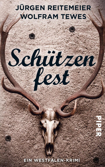 Das Buchcover zeigt ein Geweih über einem Tierkopf mit weißen Beinen vor einer strukturierten, grauen Wand. Der Titel „Schützenfest“ ist in eleganter, schwarzer Schrift prominent in der Mitte platziert. Darunter steht in kleinerer, schwarzer Schrift: „Ein Westfalen-Krimi“. Die Autoren, Jürgen Reitemeier und Wolfram Tewes, sind in einer Doppellinie oberhalb des Titels in weißer Schrift aufgeführt.