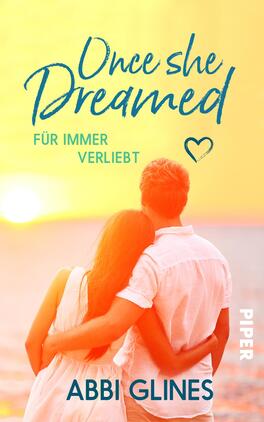 Once She Dreamed – Für immer verliebt Das Buchcover zeigt ein romantisches Szenario mit einem Paar, das sich von hinten umarmt. Der Hintergrund ist in sanften Gelb- und Orangetönen gehalten, die an einen Sonnenuntergang am Strand erinnern. Der Titel „Once she Dreamed“ ist in geschwungener blauer Schrift platziert, direkt darüber steht der Untertitel „FÜR IMMER VERLIEBT“ in schlichterer Schrift. Der Autorennamen „ABBI GLINES“ ist am unteren Rand in blauer, leicht verspielter Typografie zu sehen. Die Atmosphäre vermittelt eine warme, liebevolle Stimmung.