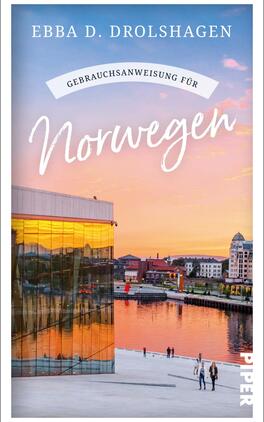 Gebrauchsanweisung für Norwegen Das Buchcover zeigt eine malerische Stadtansicht von Norwegen bei Sonnenuntergang. Dabei strahlt der Himmel in sanften Rosa- und Lilatönen. Im Vordergrund ist ein modernes Gebäude mit großen Fensterfronten abgebildet, das die warmen Farben des Himmels reflektiert. Auf dem Wasser sind Spaziergänger zu sehen, die die Atmosphäre genießen. Der Titel „Gebrauchsanweisung für Norwegen“ ist in verspielter, weißer Schrift platziert, während der Autorenname „Ebba D. Drolshagen“ in eleganter Typografie darüber steht.