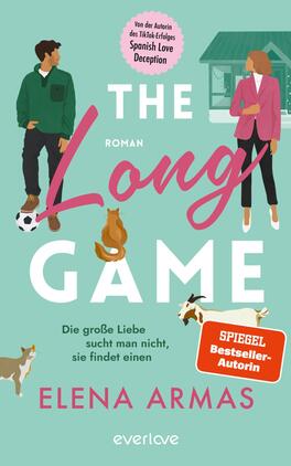 The Long Game – Die große Liebe sucht man nicht, sie findet einen Das Buchcover zeigt eine farbenfrohe Illustration mit zwei Figuren, die sich gegenüberstehen. Eine Frau in einem rosafarbenen Blazer und einem Mann in einem grünen Pullover. Zwischen ihnen sind tierische Begleiter – ein Hund und eine Katze – abgebildet. Der Titel „The Long Game“ ist prominent in pinker Schrift platziert, während „Roman“ in Weiß darunter steht. Am oberen Rand befindet sich ein Hinweis auf die Autorin, Elena Armas. Die Hintergrundfarbe ist in sanften Türkistönen gehalten, was eine frische und lebendige Atmosphäre vermittelt.