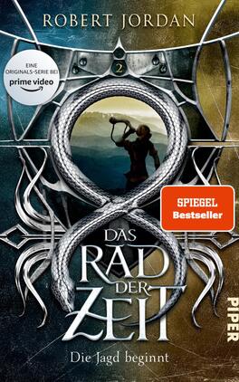 Das Rad der Zeit 2 Das Buchcover zeigt einen stilisierten, schlangenartigen Körper, der sich zu einem unendlichen Symbol windet, im Zentrum eines runden, dunklen Bildausschnitts mit einem schießenden Bogenschützen. Der Hintergrund ist in kühlen Blau- und Grautönen gehalten, während goldene Akzente eine mystische Atmosphäre erzeugen. Der Titel „DAS RAD DER ZEIT“ erscheint groß und markant in weißen Buchstaben, umgeben von filigranen, graphischen Elementen. Oben rechts ist der Hinweis „SPIEGEL Bestseller“ deutlich sichtbar.