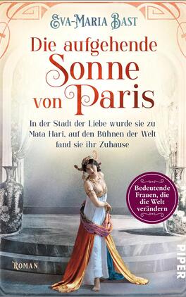 Die aufgehende Sonne von Paris Das Buchcover zeigt eine elegante Frau in historischer Kleidung, die tänzerisch posiert. Ihre lange, fließende Robe in sanften Pastellfarben hebt sich vor einem dekorativen, architektonischen Hintergrund mit Säulen und Bögen, der eine nostalgische Atmosphäre schafft. Der Titel „Die aufgehende Sonne von Paris“ steht prominent in einer geschwungenen, stilvollen Schriftart. Darunter befindet sich der Untertitel „In der Stadt der Liebe wurde sie zu Mata Hari, auf den Bühnen der Welt fand sie ihr Zuhause“. Ein runder Button links unten ist mit dem Text „Bedeutsame Frauen, die die Welt verändern“ versehen.