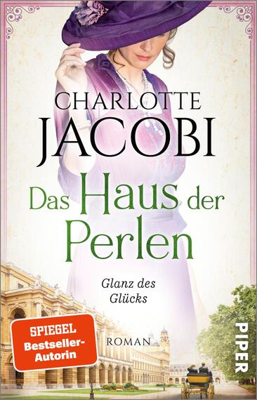 Das Buchcover zeigt eine elegante Frau in historischer Kleidung mit einem lila Hut und einem blauen Oberteil. Der Titel „Das Haus der Perlen“ ist in grüner Schrift prominent in der Mitte platziert. Darunter steht der Untertitel „Glanz des Glücks“ in kleinerer Schrift. Die Hintergrundillustration zeigt eine architektonische Szenerie, die an ein historisches Gebäude erinnert. Oben steht der Name der Autorin, Charlotte Jacobi, in schwarz. Ein rotes Label im unteren linken Bereich vermerkt „SPIEGEL-Bestseller-Autorin“.