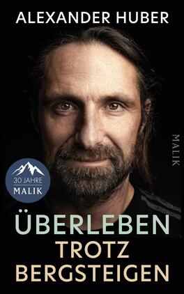 Überleben trotz Bergsteigen Das Buchcover zeigt ein dunkles, dramatisch beleuchtetes Porträt eines bärtigen Mannes mit langen Haaren und direktem Blick. Oben steht in Großbuchstaben der Autorenname Alexander Huber in weißer, serifenloser Schrift; darunter der Titel „ÜBERLEBEN TROTZ BERGSTEIGEN“ in zwei Farbtönen (mintgrün für „ÜBERLEBEN“, beige für „TROTZ BERGSTEIGEN“). Gesamtwirkung: ernst, entschlossen, zurückhaltende Farbpalette mit schwarzem Hintergrund.