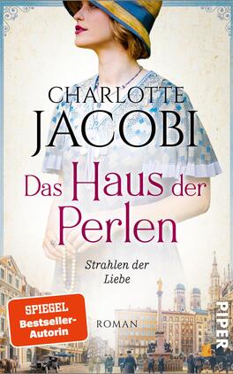 Das Haus der Perlen – Strahlen der Liebe Das Buchcover zeigt eine Frau mit einem blauen Hut und einem weißen Kleid, das fein gearbeitete Details aufweist. Der Hintergrund ist eine impressionistische Stadtlandschaft mit historischen Gebäuden und sanften Pastelltönen. Oben steht in großen, eleganten Buchstaben „CHARLOTTE JACOBI“, während der Titel „Das Haus der Perlen“ in auffälligem Pink hervorgehoben ist. Darunter steht in kleinerer Schrift „Strahlen der Liebe“. Rechts unten befindet sich das Verlagslogo „PIPER“ und ein Hinweis auf die Autorin als „SPIEGEL-Bestseller-Autorin“.