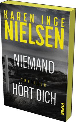Niemand hört dich Das Buchcover zeigt eine düstere Küstenlandschaft mit grauen und schwarzen Farbtönen, die eine spannungsgeladene Atmosphäre erzeugen. Im Vordergrund steht der Titel „NIEMAND HÖRT DICH“ in auffälliger weißer Schrift, während der Autorname „KAREN INGE NIELSEN“ in großen gelben Buchstaben oben platziert ist. Der Untertitel „Thriller“ ist in einer schmalen Schriftart in der Mitte des Covers abgebildet. Der Verlag „PIPER“ ist am unteren Rand angegeben.