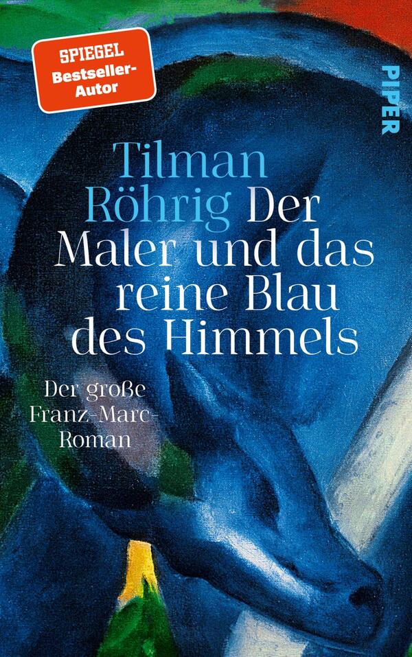 Das Buchcover zeigt einen farbenfrohen, expressionistischen Hintergrund in blauen und roten Tönen. Im Vordergrund ist ein blaues Pferd, das elegant und kraftvoll wirkt. Der Titel „Der Maler und das reine Blau des Himmels“ und der Autor „Tilman Röhrig“ sind in großer, weißer Schrift zentral platziert. Darunter steht in kleinerer Schrift „Der große Franz-Marc-Roman“. Oben befindet sich ein rotes Rechteck mit dem Hinweis „SPIEGEL Bestseller-Autor“.
